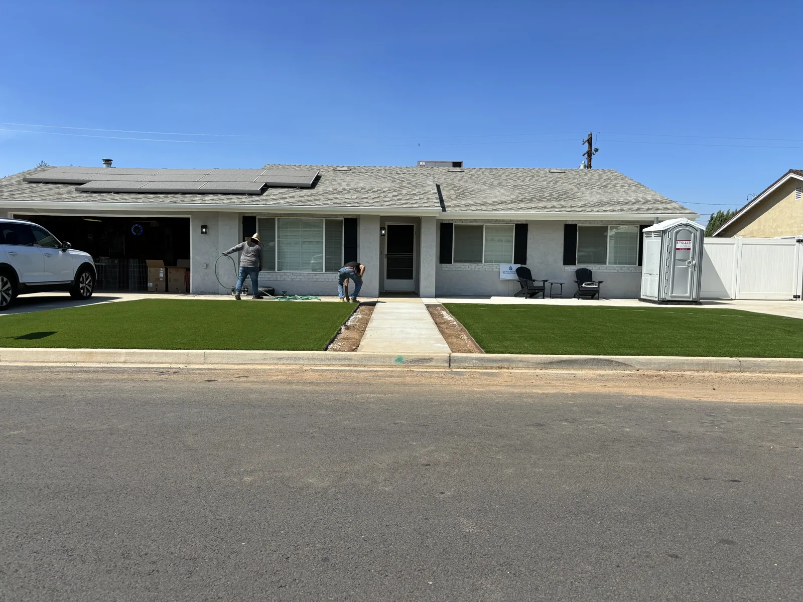 Front yard landscaping with green lawn areas and a straight path to the front door