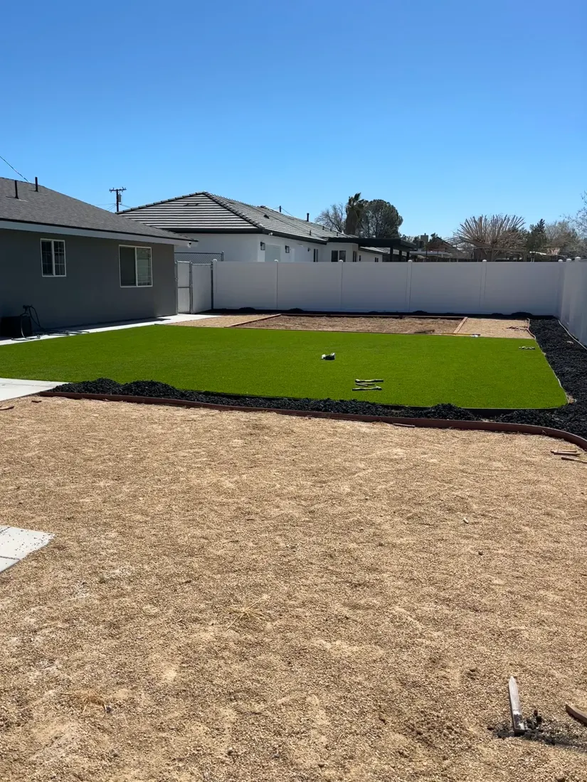 A lawn area and surrounding yard during a landscape project