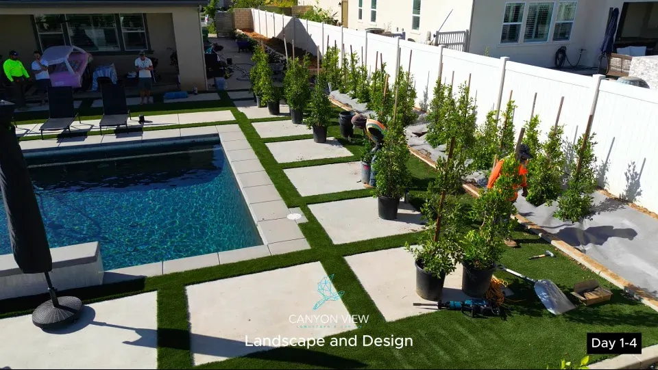 Poolside rectangular concrete areas with green borders and planting work in progress